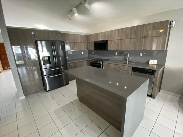 a kitchen with stainless steel appliances granite countertop a refrigerator and a stove
