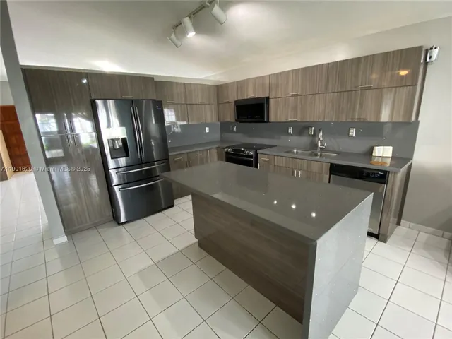 a kitchen with stainless steel appliances granite countertop a refrigerator and a stove