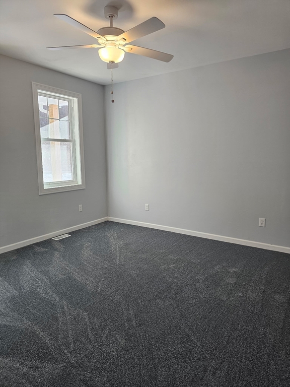 88 Stafford Holland Road Wales, MA 01081 - Photo 10 of 31 an empty room with a window and a fan