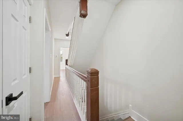 a view of a hallway with a white walls and stairs