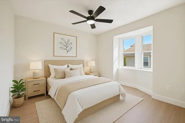 a bedroom with a bed and a large window