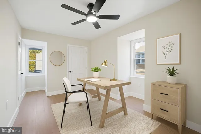 a view of a workspace room with furniture and wooden floor