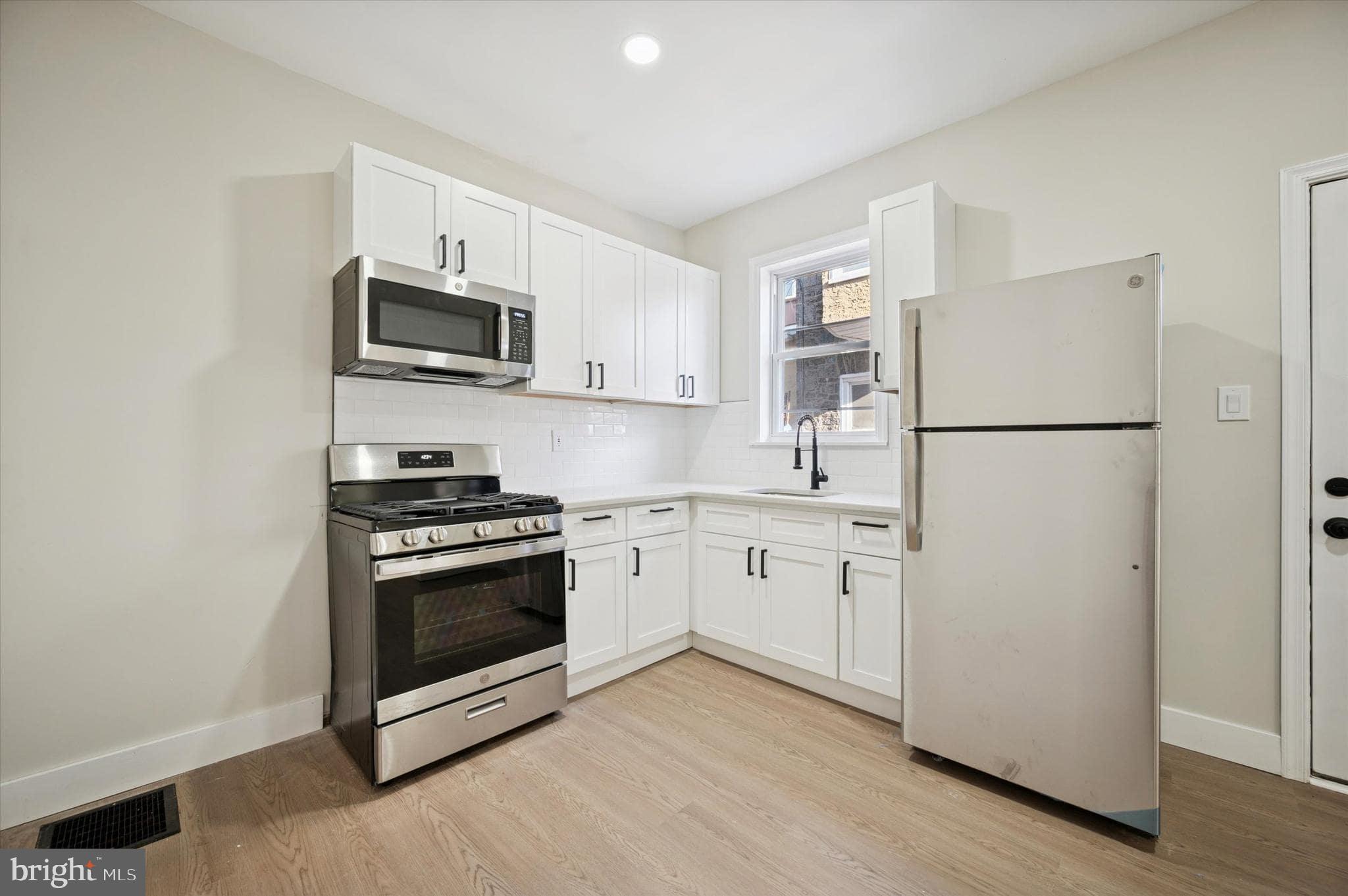 75 High Street Philadelphia, PA 19144 - Photo 2 of 20 a kitchen with white cabinets and stainless steel appliances