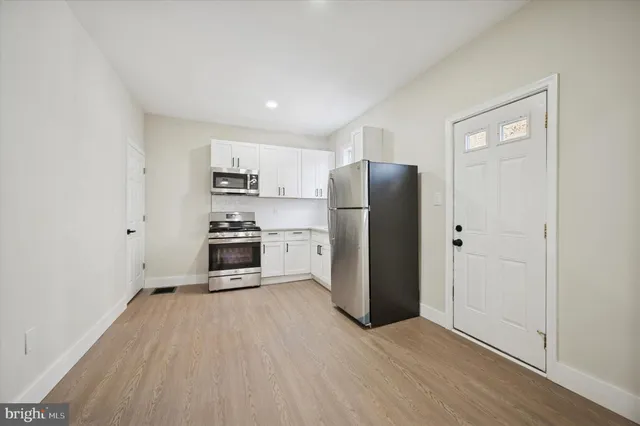 a kitchen with stainless steel appliances a refrigerator and a stove top oven