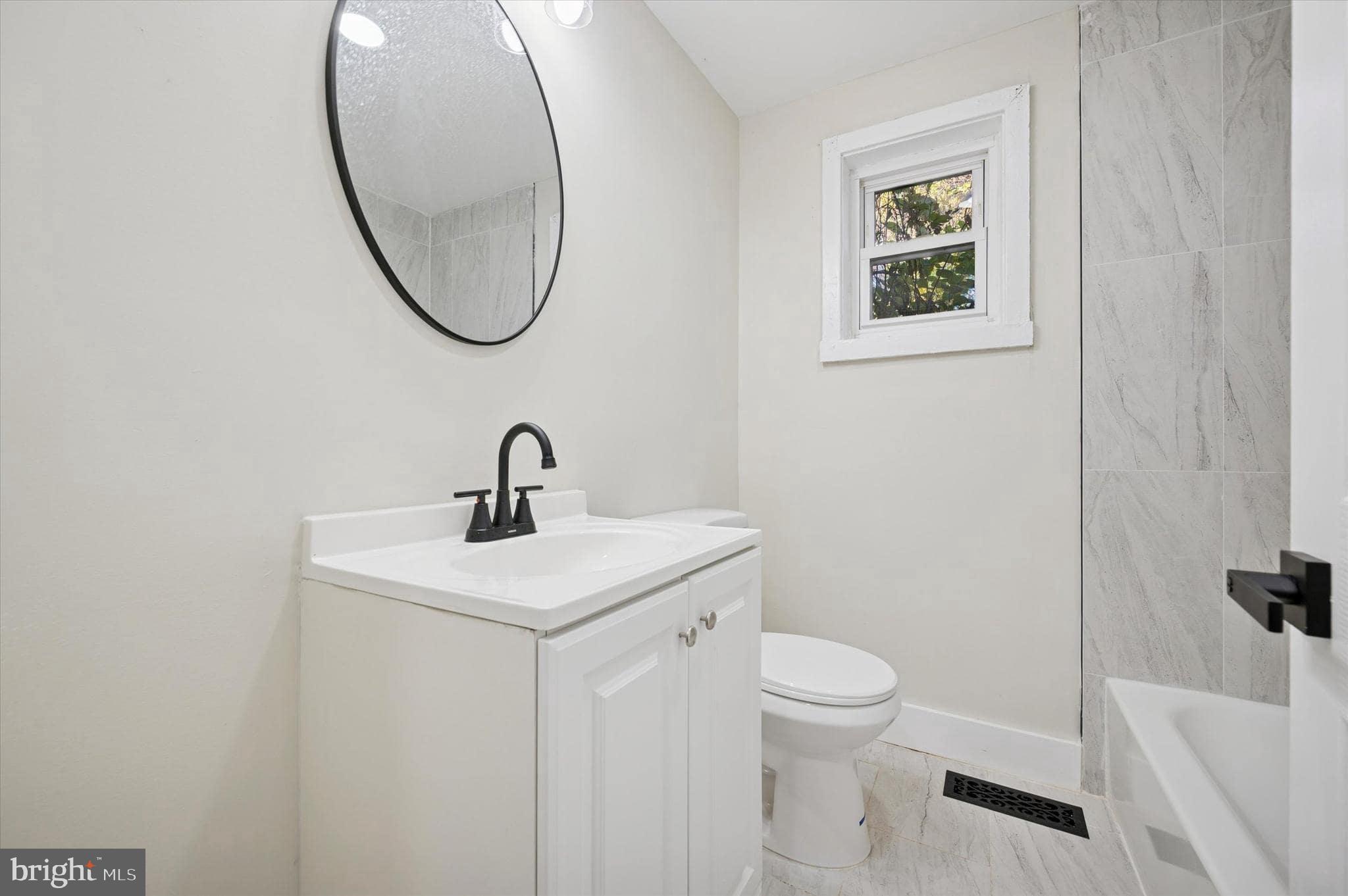 75 High Street Philadelphia, PA 19144 - Photo 6 of 20 a bathroom with a sink a mirror and a toilet