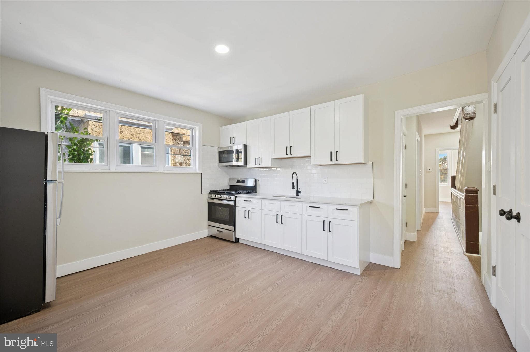 75 High Street Philadelphia, PA 19144 - Photo 8 of 20 a kitchen with white cabinets and white appliances