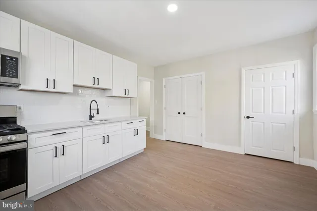 a kitchen with granite countertop white cabinets and white appliances