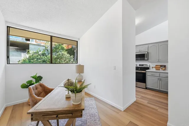 a view of a dining room with furniture a potted plant and wooden floor
