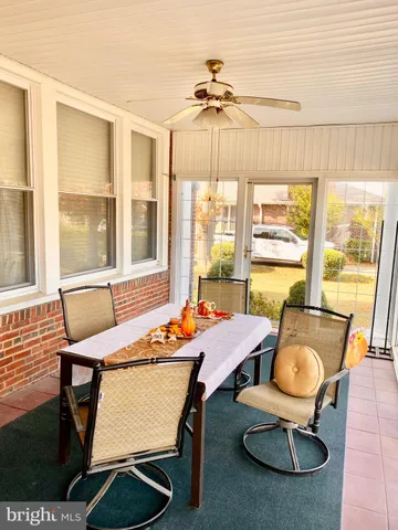 a dining room with furniture a chandelier and wooden floor