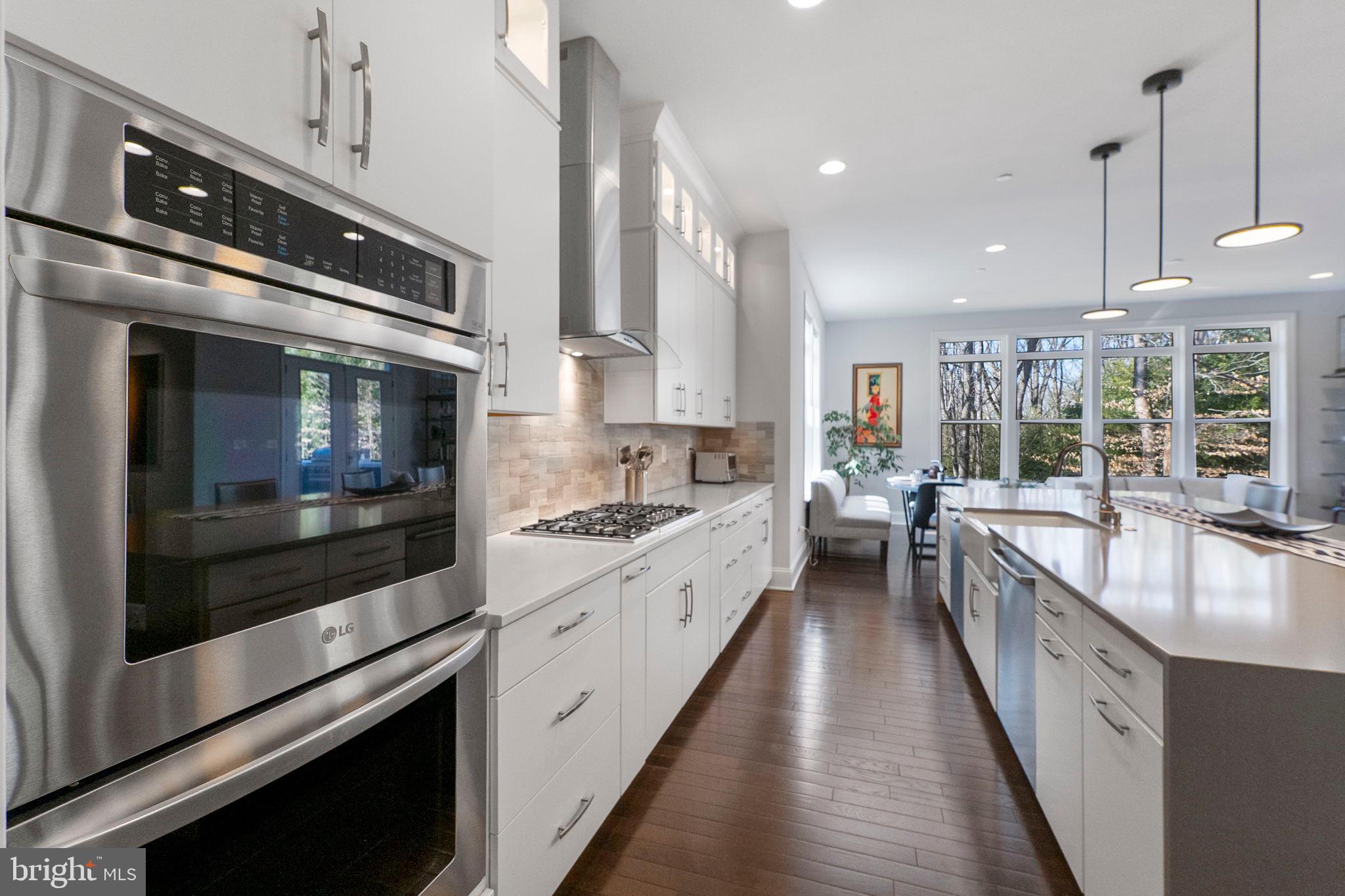 11760 Glen Mill Road Potomac, MD 20854 - Photo 17 of 64 a kitchen with stainless steel appliances kitchen island granite countertop a stove a sink and a microwave