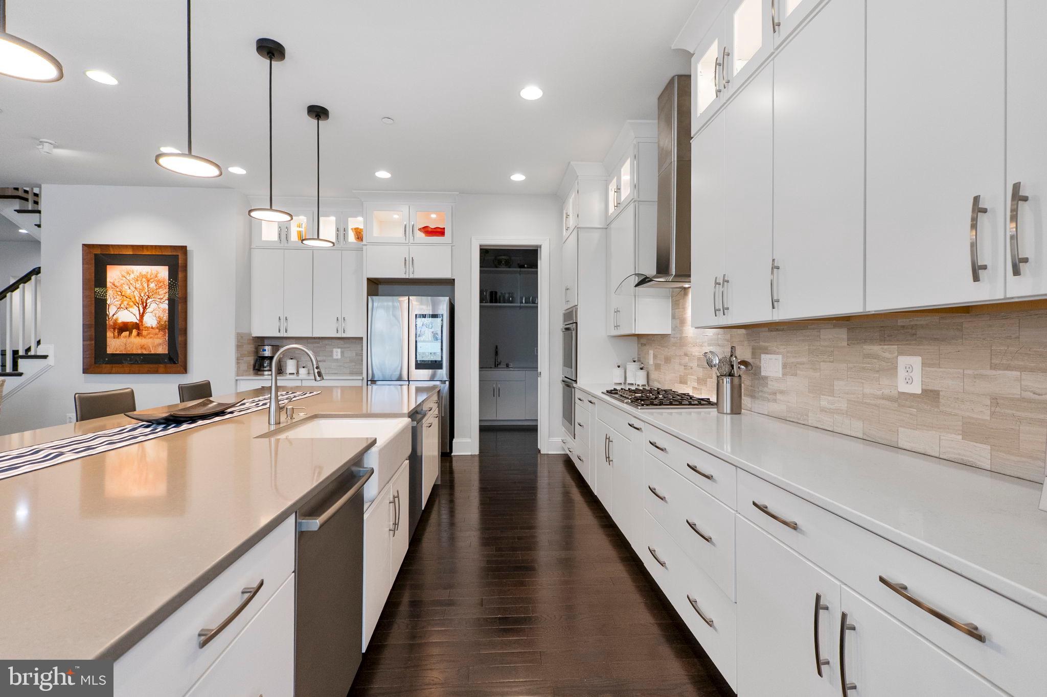 11760 Glen Mill Road Potomac, MD 20854 - Photo 18 of 64 a large kitchen with kitchen island granite countertop lots of counter space and wooden floor