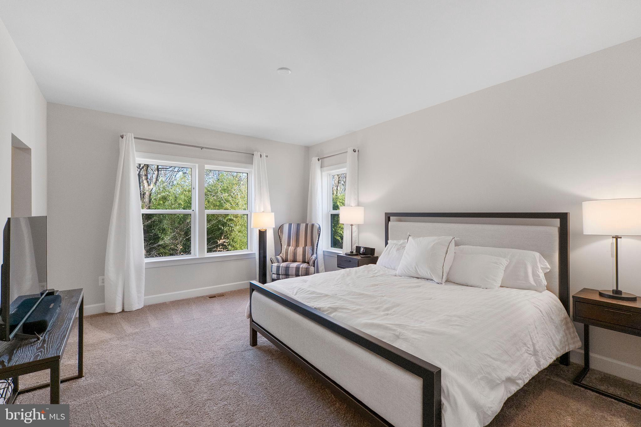 11760 Glen Mill Road Potomac, MD 20854 - Photo 36 of 64 a bedroom with a large bed and a flat tv screen on a dresser