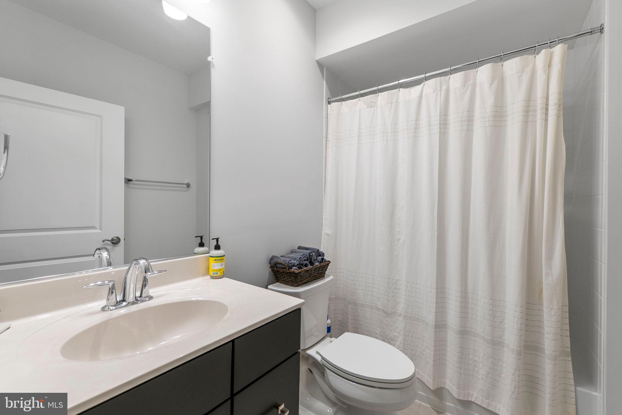11760 Glen Mill Road Potomac, MD 20854 - Photo 43 of 64 a bathroom with a sink a toilet a mirror and shower curtain