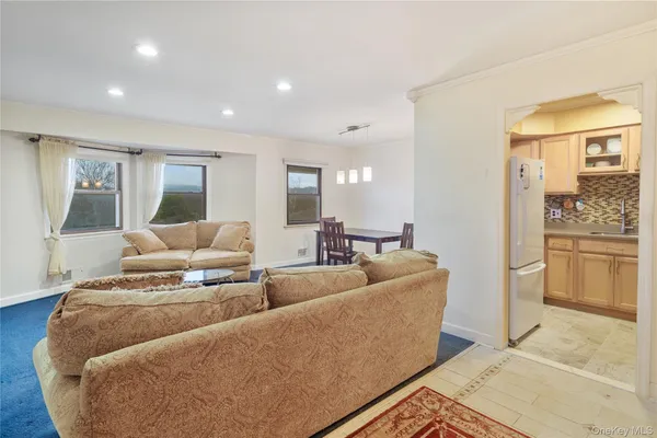 a living room with furniture and a view of kitchen