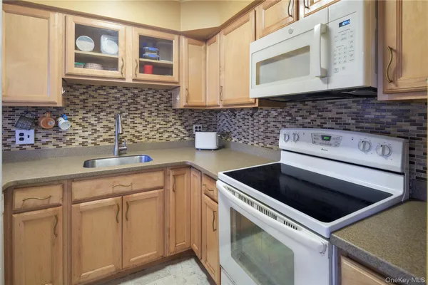 a kitchen with white cabinets and white appliances