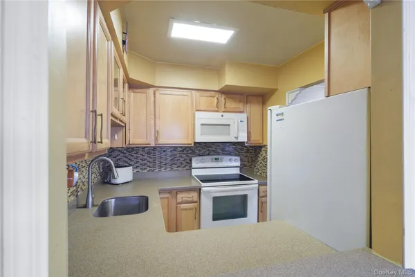 a kitchen with kitchen island a stove a refrigerator and a sink