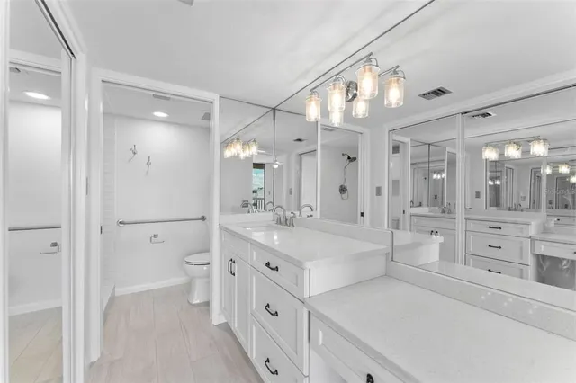a spacious bathroom with a double vanity sink a mirror a bathtub and a shower
