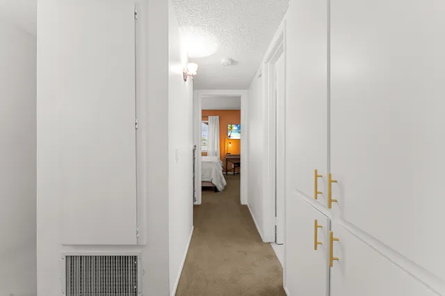 a view of a hallway with wooden floor and closet