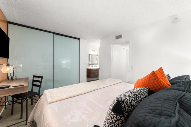 a bedroom with a bed and a lamp on table