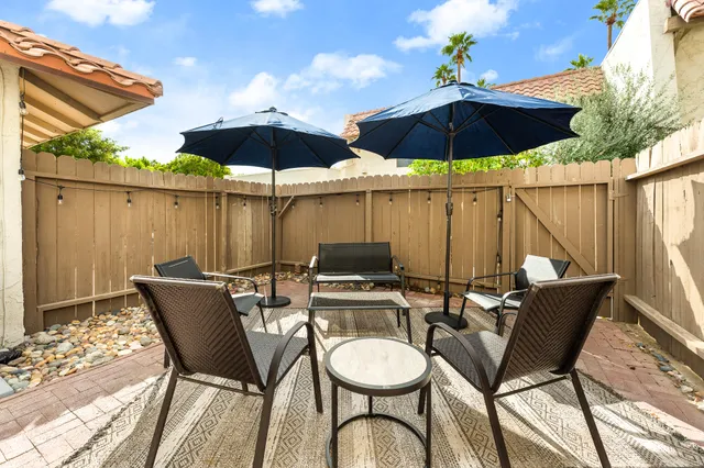 a patio with a table and chairs under an umbrella