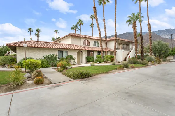 a front view of a house with a yard and potted plants