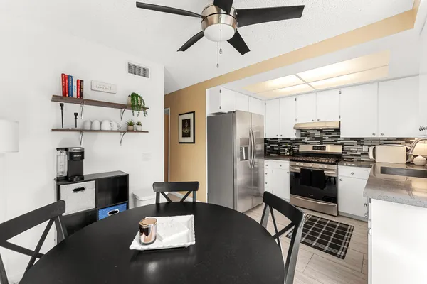 a kitchen with stainless steel appliances kitchen island granite countertop a stove and a refrigerator