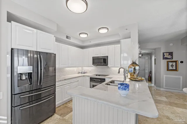 a kitchen with stainless steel appliances granite countertop a sink and a refrigerator
