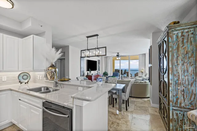 a living room with stainless steel appliances furniture a fireplace a flat screen tv and a window