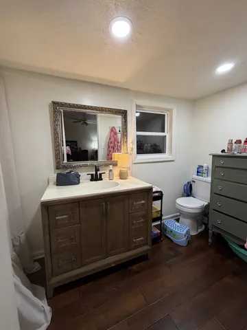 a bathroom with a sink mirror and toilet