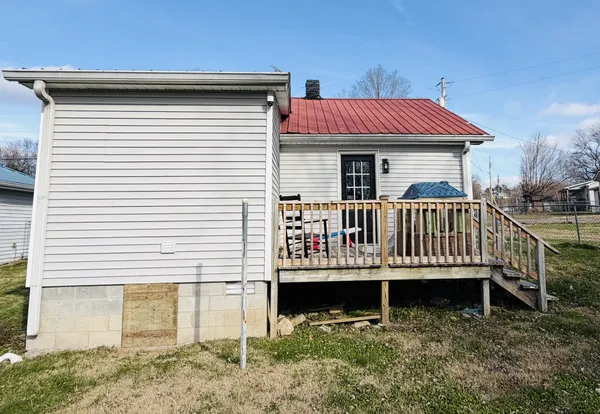 a view of a house with a small deck and a yard