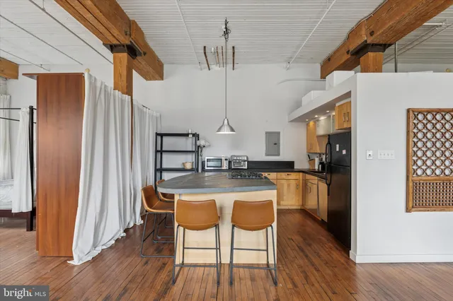 a kitchen with stainless steel appliances a dining table chairs and wooden floor