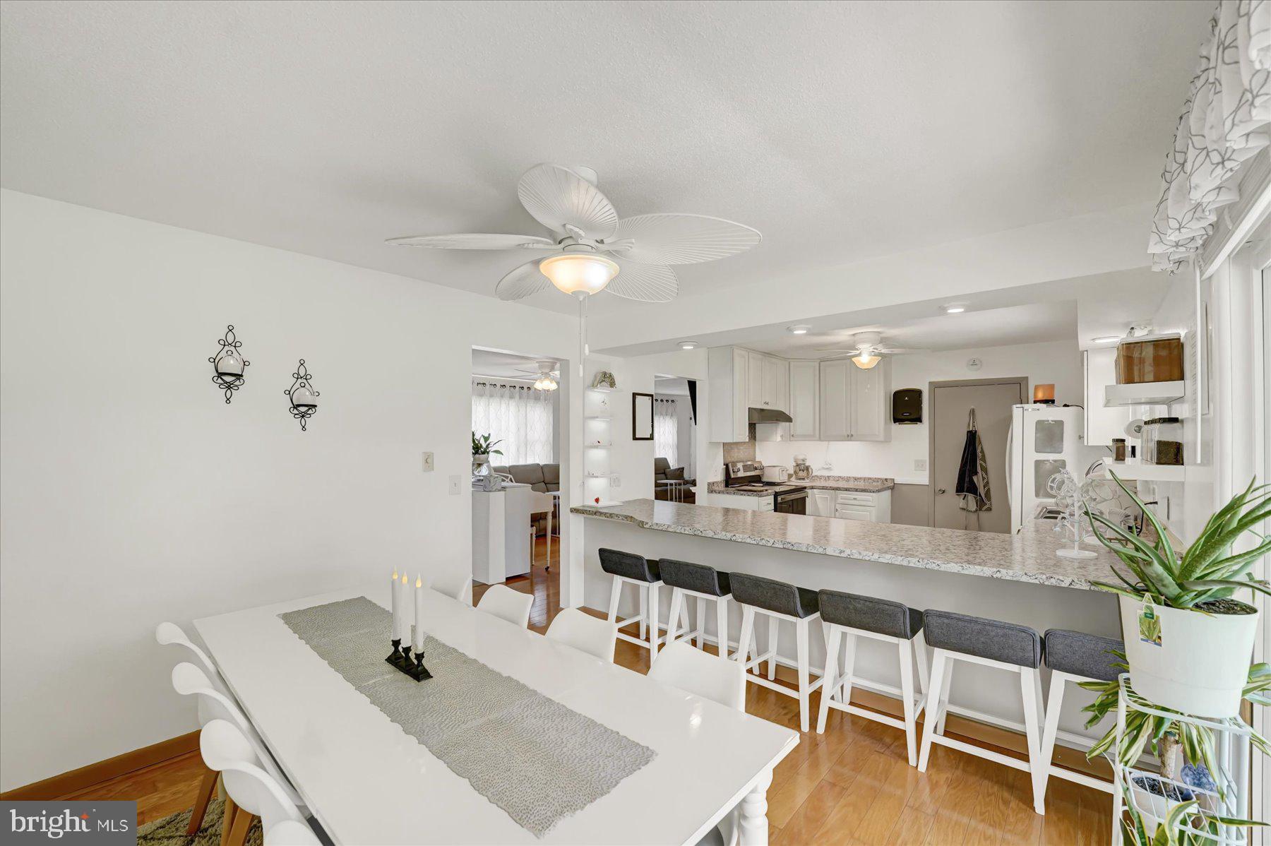 4814 West Whitehall Road Pennsylvania Furnace, PA 16865 - Photo 10 of 43 a dining room with stainless steel appliances kitchen island granite countertop a sink a stove and white cabinets with wooden floor