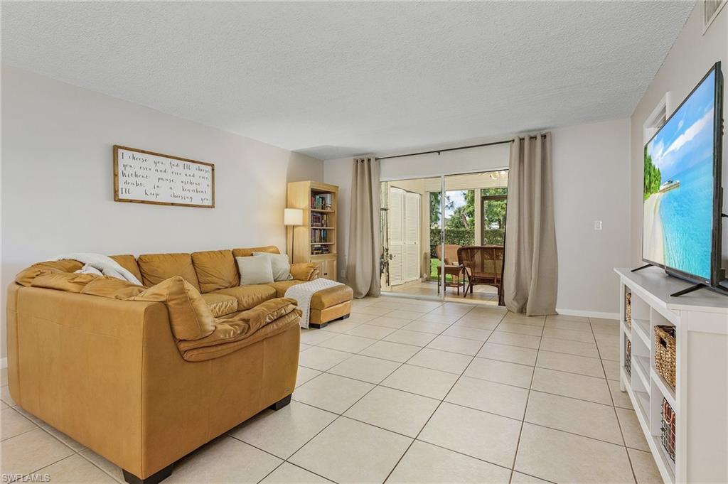 5789 Gage Lane, Unit A 103 Naples, FL 34113 - Photo 11 of 26 a living room with furniture and a flat screen tv