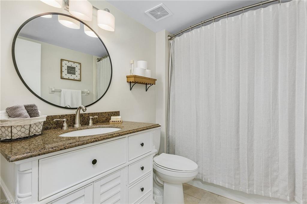 5789 Gage Lane, Unit A 103 Naples, FL 34113 - Photo 15 of 26 a bathroom with a granite countertop sink and a mirror