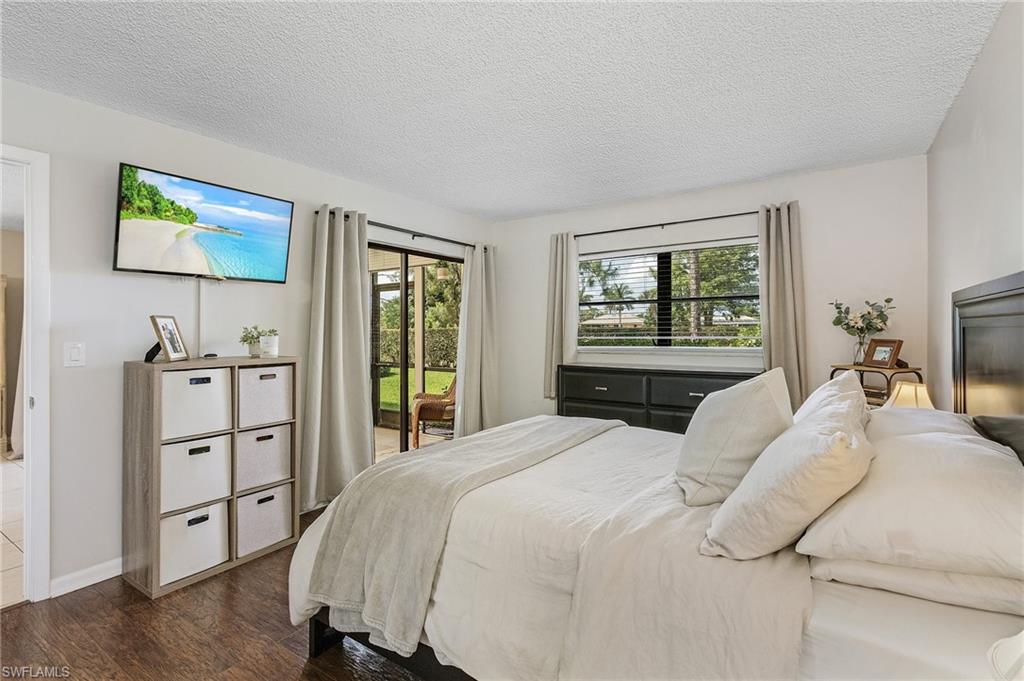 5789 Gage Lane, Unit A 103 Naples, FL 34113 - Photo 17 of 26 a bedroom with a bed and a flat screen tv