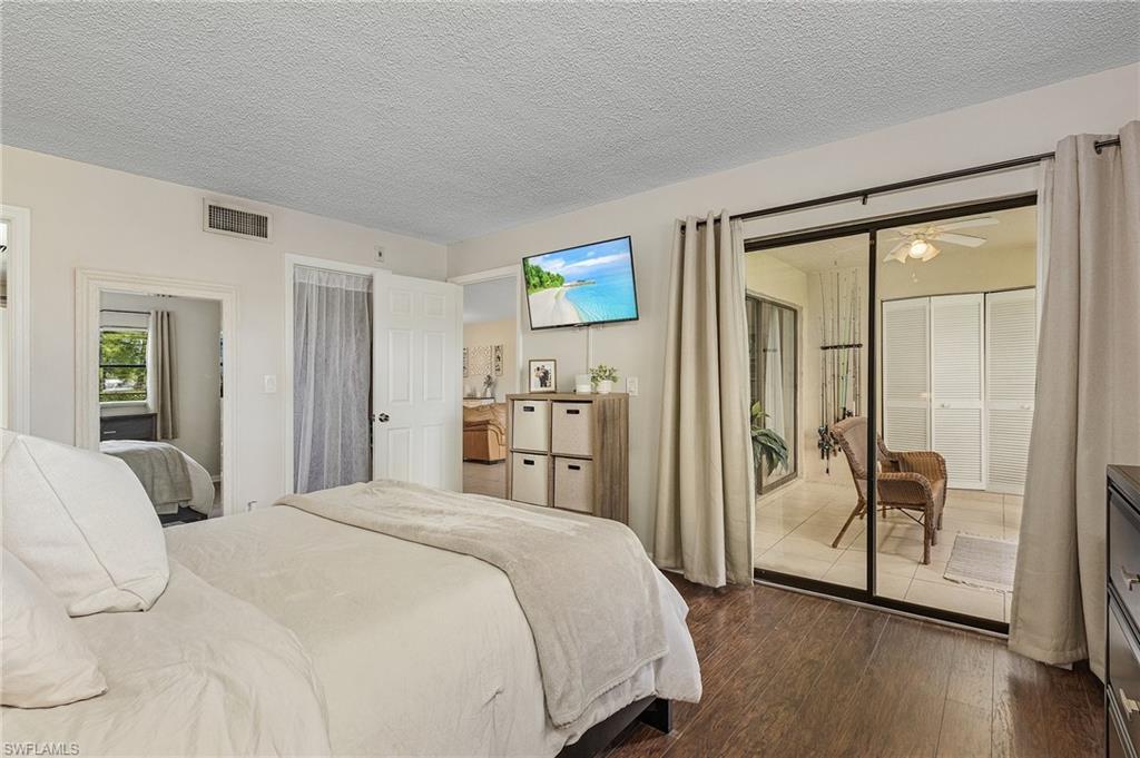 5789 Gage Lane, Unit A 103 Naples, FL 34113 - Photo 18 of 26 a bedroom with a bed and a mirror