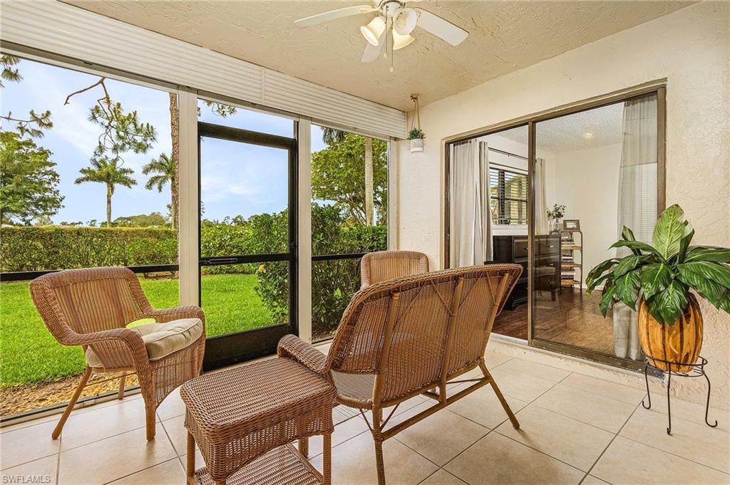 5789 Gage Lane, Unit A 103 Naples, FL 34113 - Photo 20 of 26 a living room with furniture and a floor to ceiling window