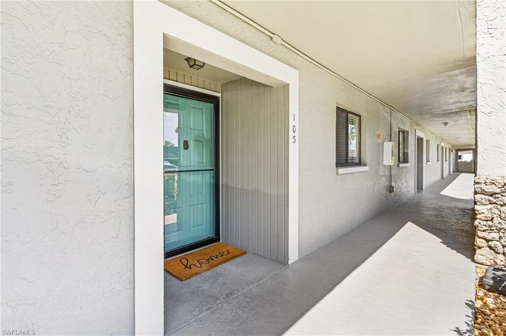 5789 Gage Lane, Unit A 103 Naples, FL 34113 - Photo 3 of 26 a view of a hallway with wooden floor and a living room