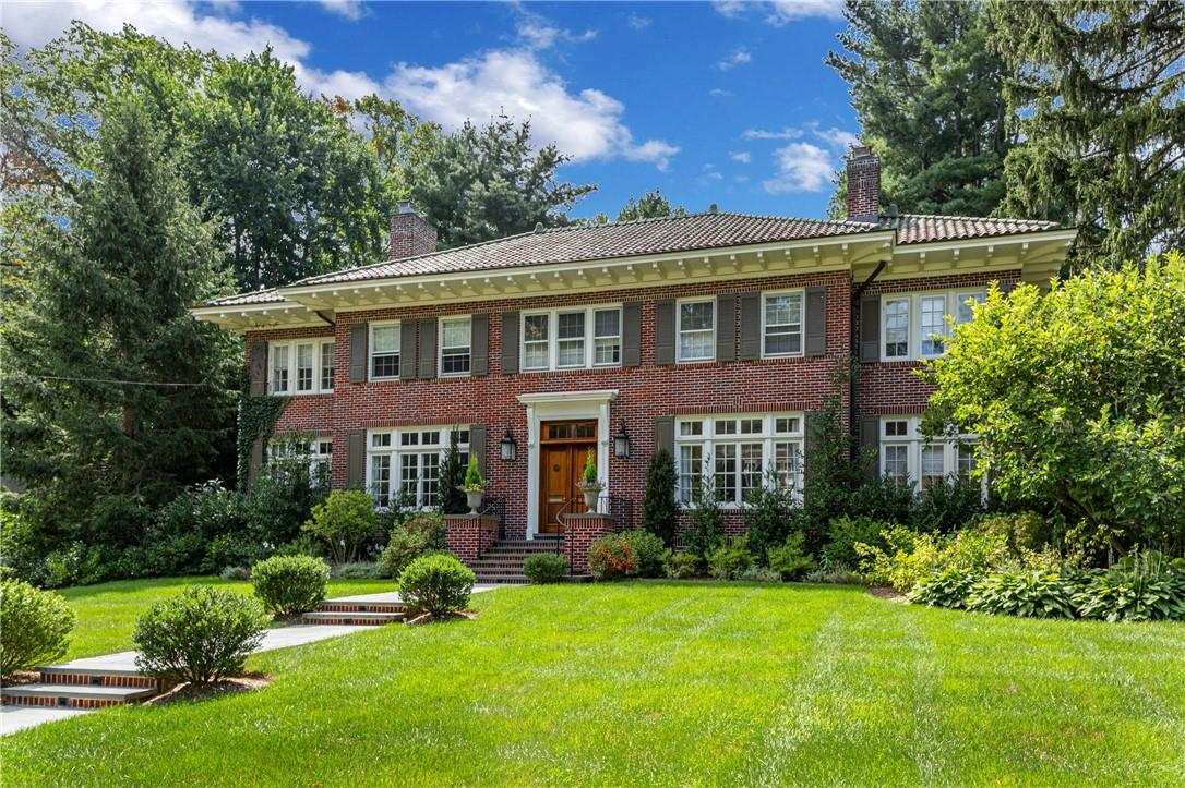 a front view of a house with yard and green space