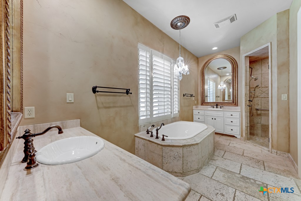 1108 Tuscan Ridge Drive New Braunfels, TX 78130 - Photo 26 of 47 a bathroom with a granite countertop sink toilet a mirror and shower
