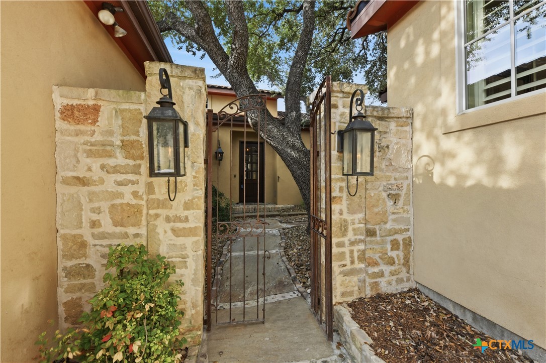 1108 Tuscan Ridge Drive New Braunfels, TX 78130 - Photo 4 of 47 IRON ENTRY GATE FLANKED BY GAS LANTERNS