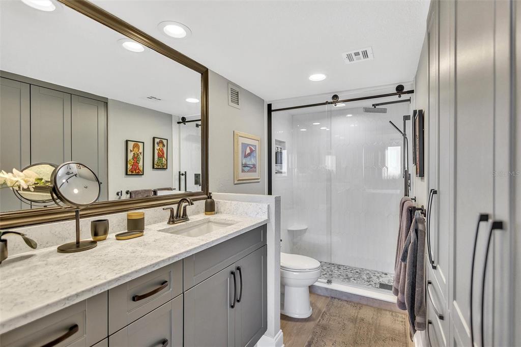 4822 Ocean Boulevard, Unit 8D Siesta Key, FL 34242 - Photo 29 of 69 a bathroom with a granite countertop sink toilet and shower