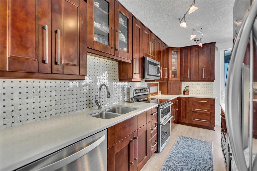 4822 Ocean Boulevard, Unit 8D Siesta Key, FL 34242 - Photo 40 of 69 a kitchen with stainless steel appliances granite countertop a sink stove and cabinets