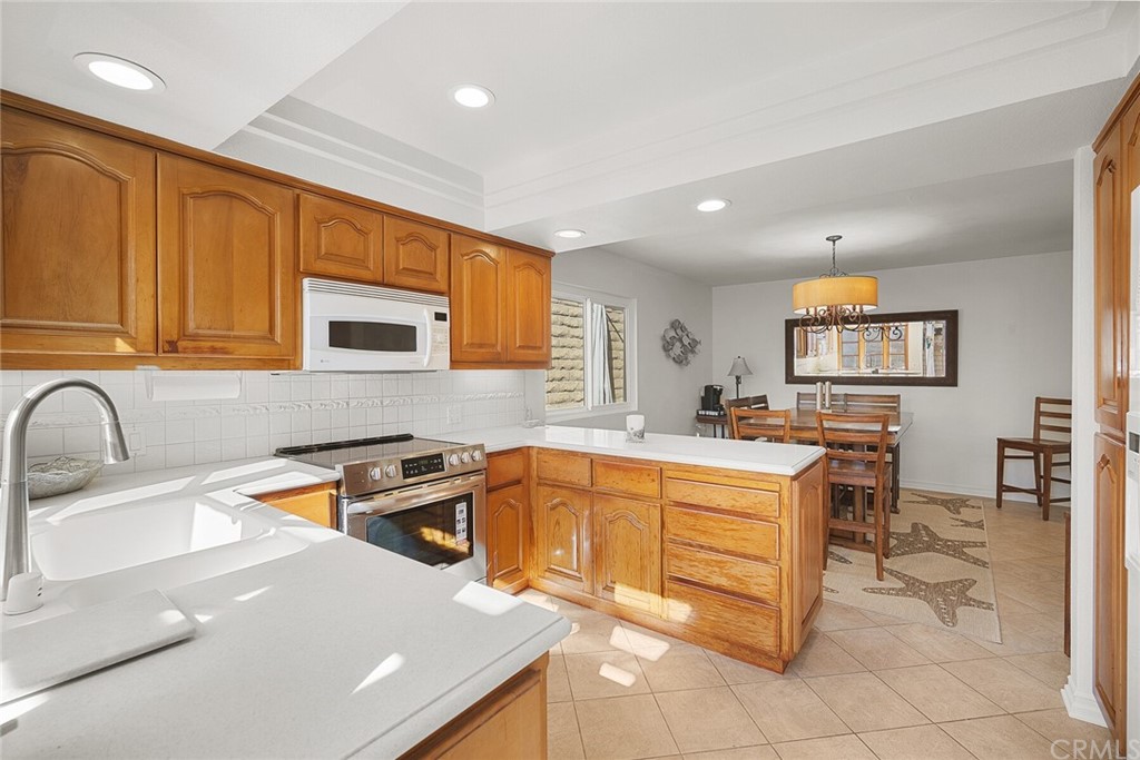 23892 Taranto Bay Dana Point, CA 92629 - Photo 21 of 73 a kitchen with stainless steel appliances granite countertop a sink and a stove top oven with wooden floor