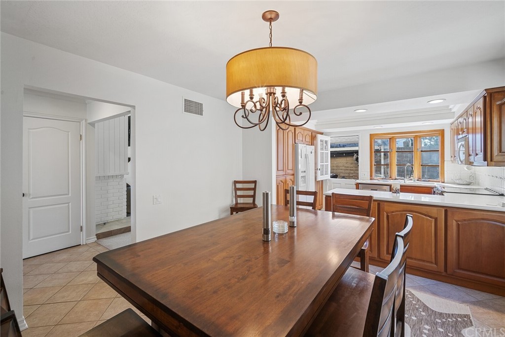 23892 Taranto Bay Dana Point, CA 92629 - Photo 23 of 73 a dining room with wooden floor a chandelier a wooden table and chairs