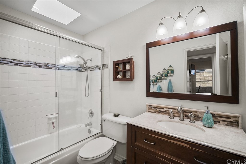 23892 Taranto Bay Dana Point, CA 92629 - Photo 31 of 73 a bathroom with a granite countertop sink toilet a mirror a vanity and shower