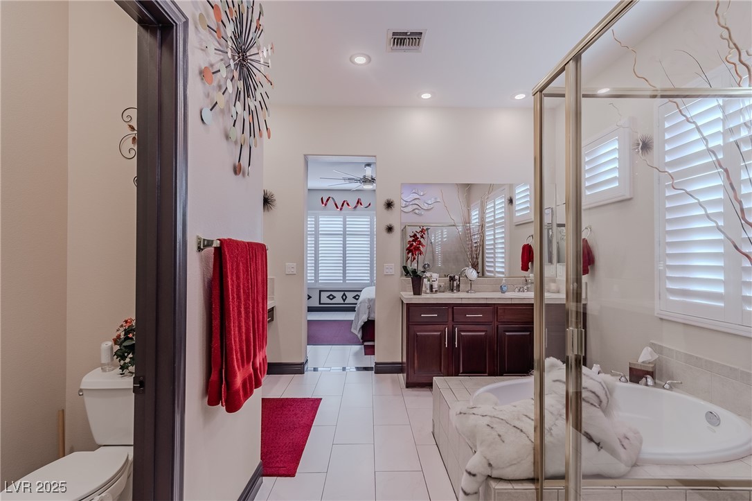 17 Chatmoss Road Henderson, NV 89052 - Photo 25 of 58 Ensuite bathroom with ceiling fan, a bath, ensuite bathroom, vanity, and visible vents