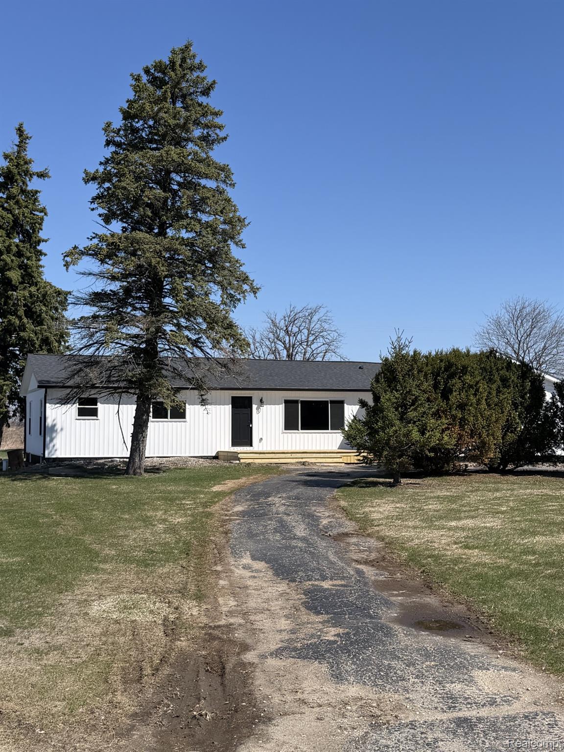 5614 West Marlette Road Marlette, MI 48453 - Photo 1 of 25 View of front of house with driveway, board and batten siding, and a front lawn