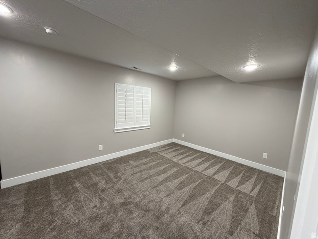 2350 North 1075 West Helper, UT 84526 - Photo 32 of 49 Spare room featuring a textured ceiling and dark carpet