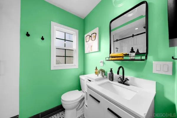 a bathroom with a toilet sink and mirror